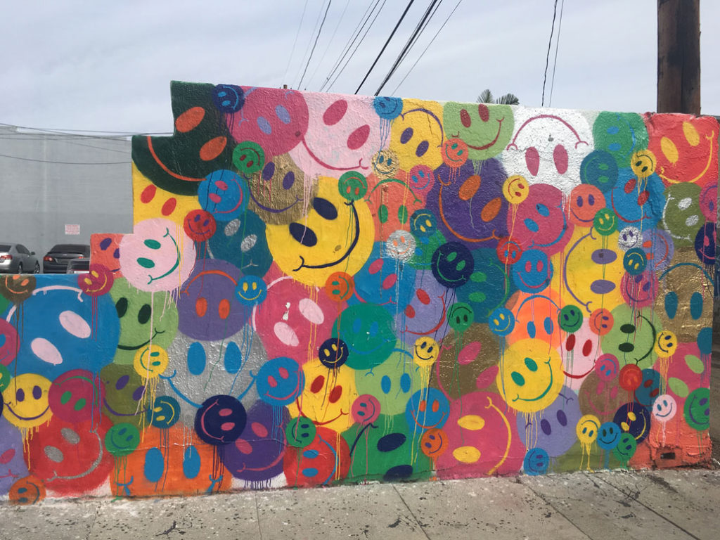 Wall of colorful smiley faces in Mural Alley